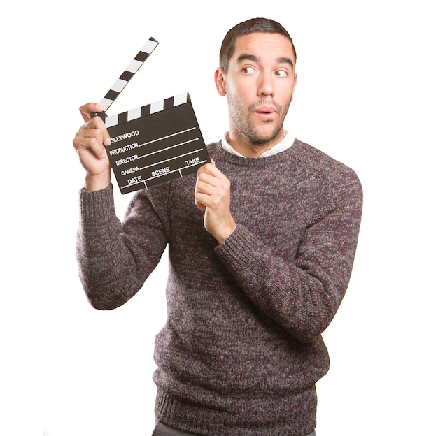 Photo funny young man using a clapperboard