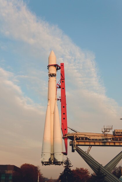 Une fusée spatiale prête à partir avec un ciel nuageux bleu en arrière-plan.
