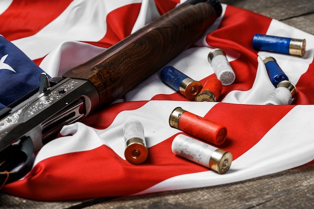 Photo fusil automatique sur le drapeau américain sur fond de bois