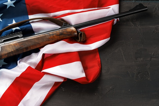 Photo fusil automatique sur le drapeau américain sur fond de bois