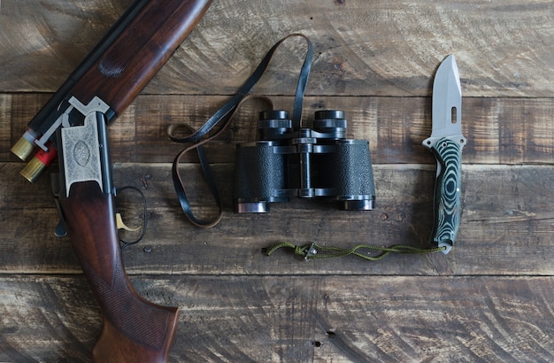 Fusil de chasse avec des jumelles et un couteau. Vue de dessus.