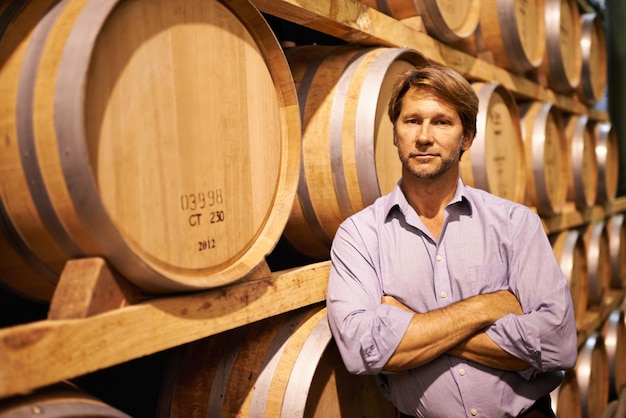 Ce fut une année exceptionnelle pour notre vignoble Photo d'un bel homme mûr debout dans une cave à vin