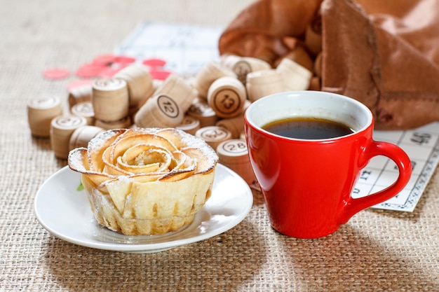 Fûts de loto en bois dans une pochette marron et cartes de jeu pour un jeu de loto avec une tasse de café