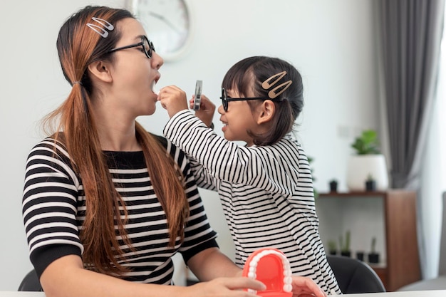 Futur médecin vérifiant le dentier de la mère à la maison