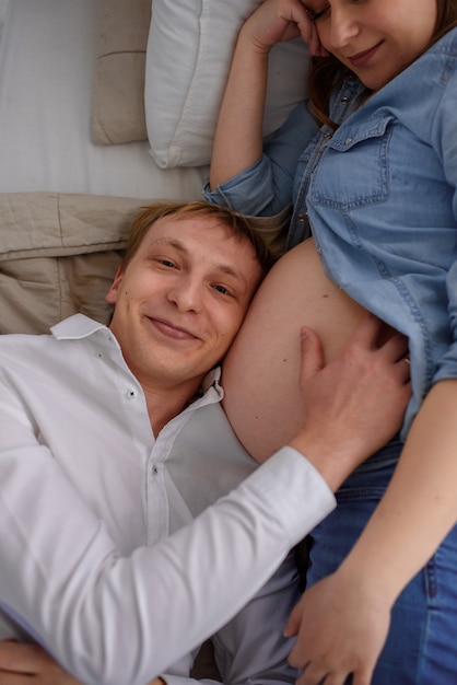 Photo le futur père écoute son enfant battre dans le ventre de sa femme enceinte.