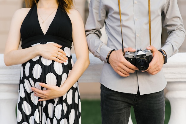 La future mère tient ses mains sur son ventre de femme enceinte.