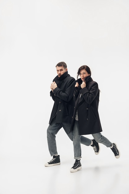 Fuyez. Couple à la mode à la mode isolé sur le mur du studio blanc.