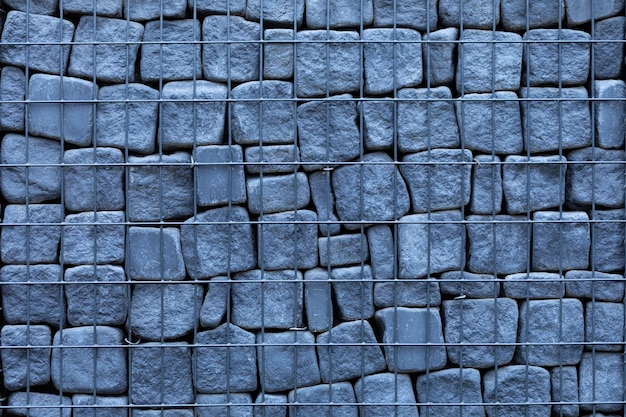 Gabion en pierre grise. Texture. Maille en métal grillé durable.