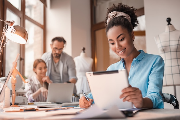 Gadgets aidant avec un groupe de design de trois personnes au studio de design