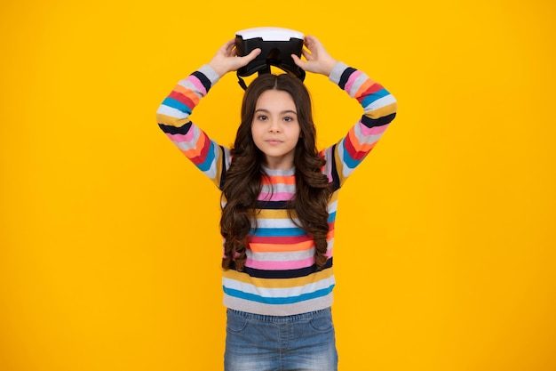 Gadgets virtuels pour le temps libre et l'étude des enfants Une écolière adolescente utilise des lunettes vr isolées sur fond jaune studio shot
