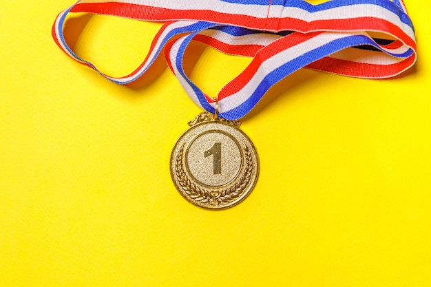 Gagnant du design simplement plat ou médaille du trophée d'or champion isolé sur fond coloré jaune. Victoire première place de la compétition. Concept gagnant ou réussi. Espace de copie vue de dessus.