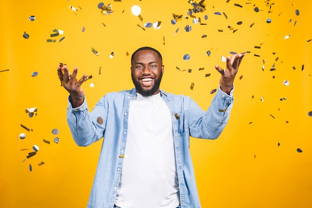 Photo gagnant! gai jeune homme afro-américain dansant sur fond jaune.