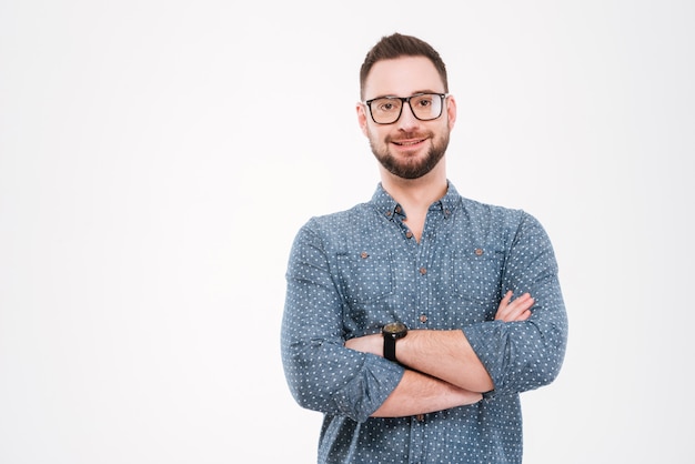 Gai homme barbu debout avec les mains croisées