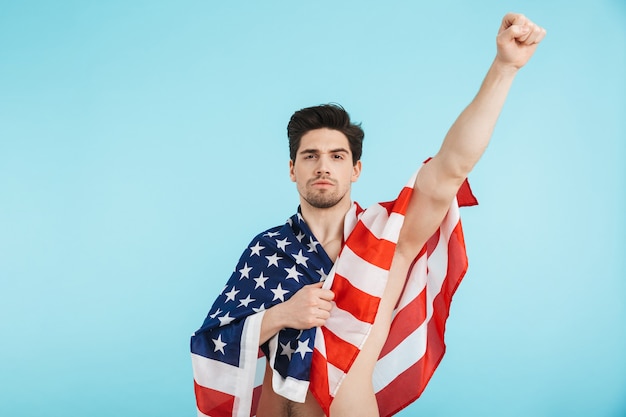 Gai homme torse nu debout isolé, portant le drapeau américain, célébrant le succès