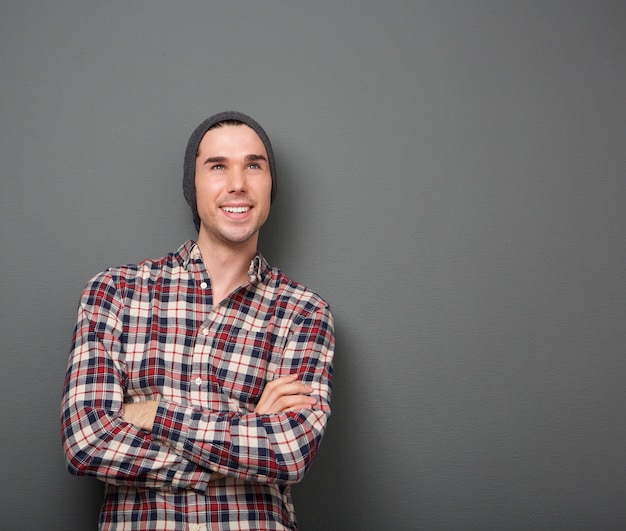 Gai jeune homme souriant avec les bras croisés