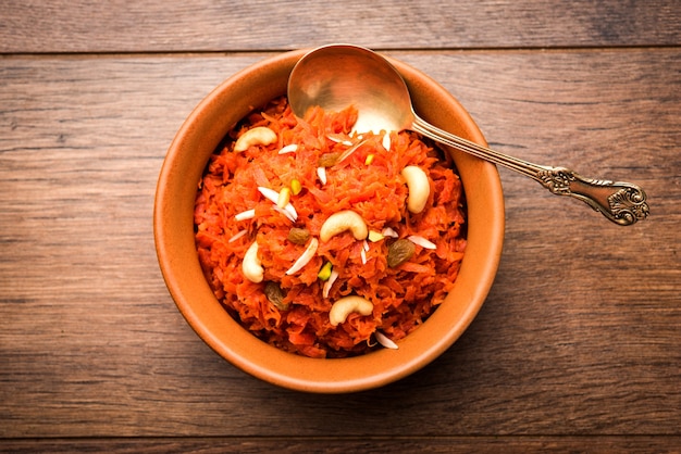 Gajar ka halwa est un pudding sucré à base de carottes originaire d'Inde. Garni de noix de cajou aux amandes. servi dans un bol.