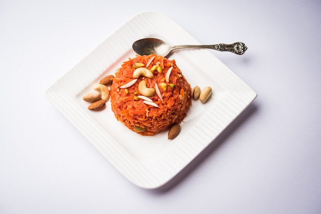 Gajar ka halwa est un pudding sucré à base de carottes originaire d'Inde. Garni de noix de cajou aux amandes. servi dans un bol.