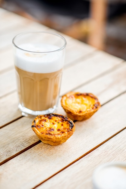 Galao de café portugais avec dessert sucré pastel de Nata sur la table à l'extérieur