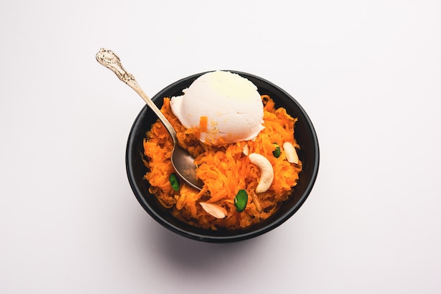 Galar Halwa avec crème glacée à la vanille, servi dans un bol et garni de fruits secs. mise au point sélective