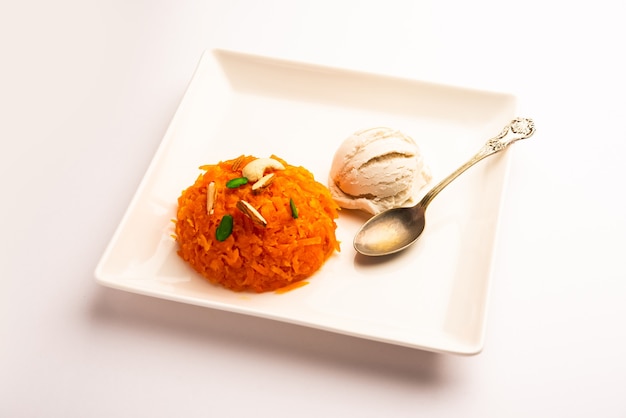 Galar Halwa avec crème glacée à la vanille, servi dans un bol et garni de fruits secs. mise au point sélective