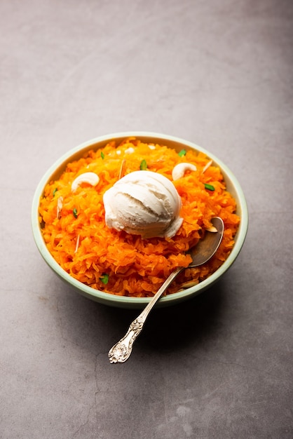 Galar Halwa avec crème glacée à la vanille, servi dans un bol et garni de fruits secs. mise au point sélective