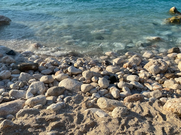 Galets au bord de la mer Vagues soyeuses de la mer bleue