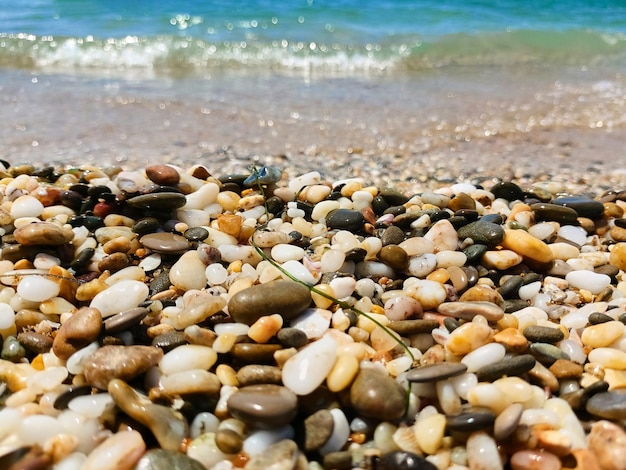 Galets de mer gros plan vagues de la mer bleue soleil brillant et écume de mer mise au point sélective