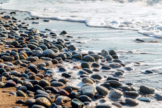 Galets de mer lavés par les vagues au lever du soleil