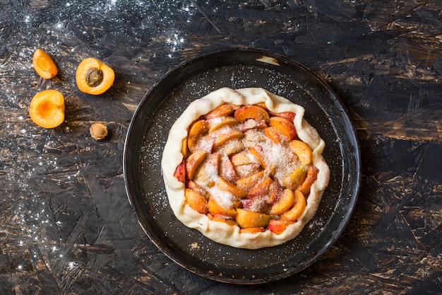 galette d&#39;abricot. Processus de cuisson. Faire de la dought. Mains avec de la poussière. Tarte ouverte, abricot ta