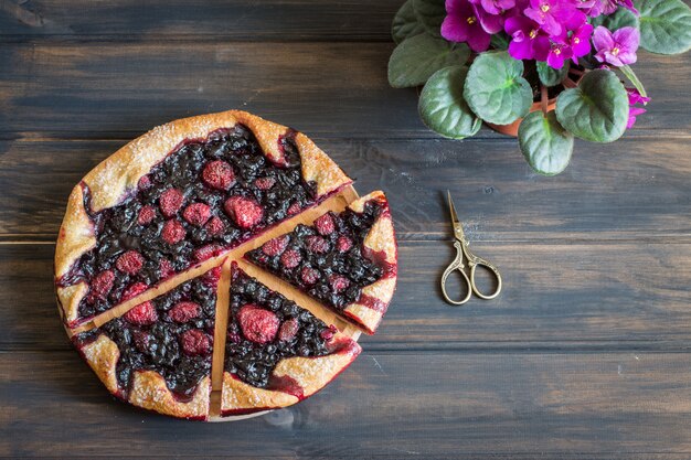 galette, baies, fraises, myrtilles. Fleur violette et ciseaux vintage. il végétarien