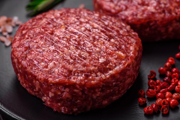 Galette de burger de boeuf haché cru frais avec du sel et des épices