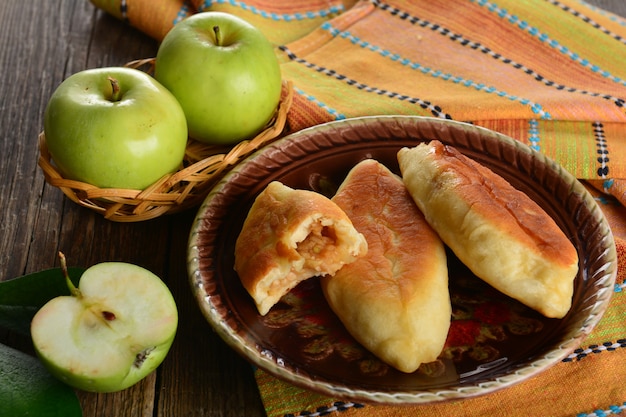 Galette chaude avec des pommes vertes fraîches sur fond de bois