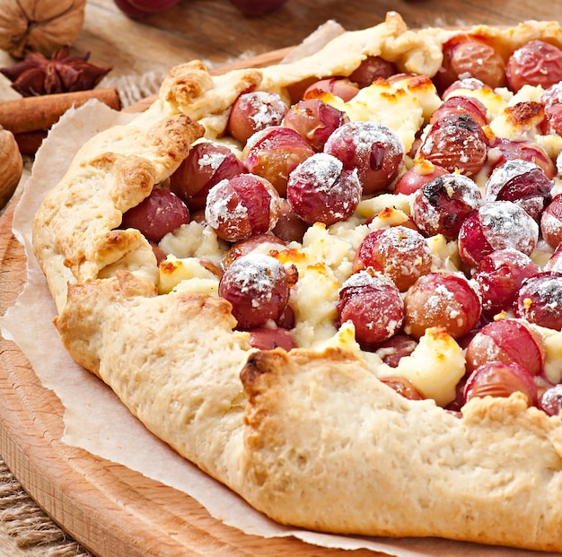 Photo galette avec des raisins et du fromage saupoudré de sucre en poudre