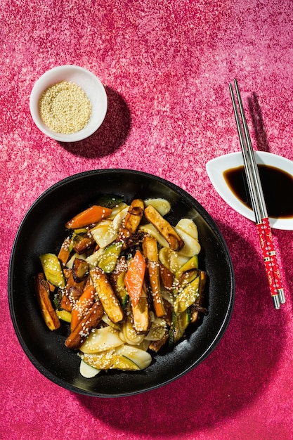 Galette de riz aux légumes dans l'assiette servie avec sauce soja