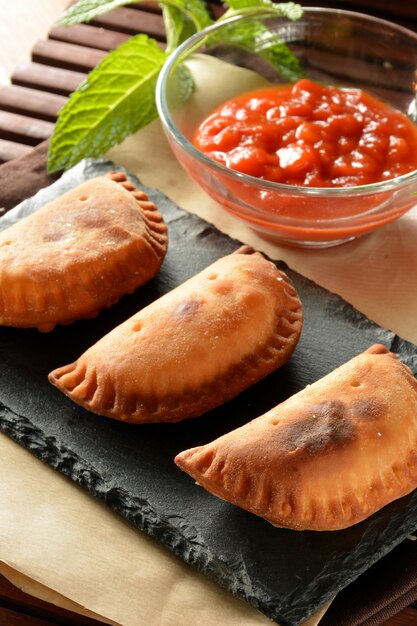 Galette de thon maison à la sauce tomate sur une table en bois