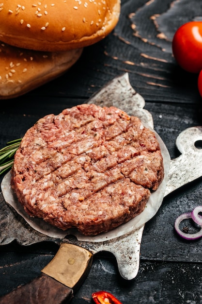 Galettes de hamburger viande hachée pour burger boeuf viande d'agneau Burger steak sur un fond en bois vertical image vue de dessus place pour le texte
