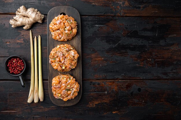 Galettes de poisson cru asiatique rapide avec des herbes sur la vieille table en bois