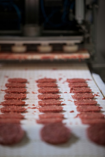 Galettes de viande crue sur la chaîne de montage au facteur viande