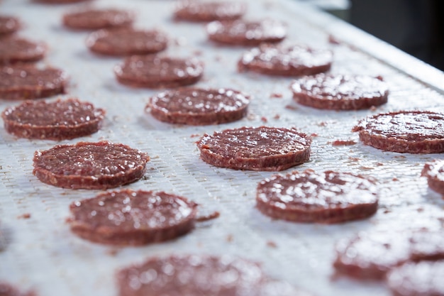 Galettes de viande crue sur chaîne de montage