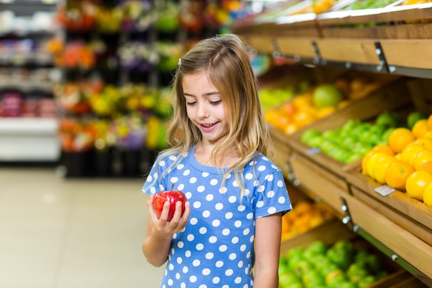 Gamin mignon regardant une pomme