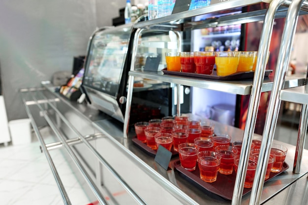 Une gamme colorée de tasses de jus de fruits sur un chariot de service dans une cafétéria