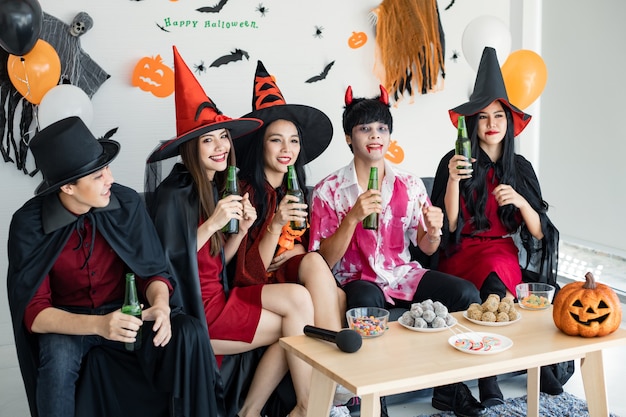 Gang de jeunes asiatiques en costume de sorcière, sorcier avec fête d'Halloween pour danser et boire et ivre dans la chambre. Groupe teen Thai avec fêter Halloween. Fête de concept Halloween à la maison.