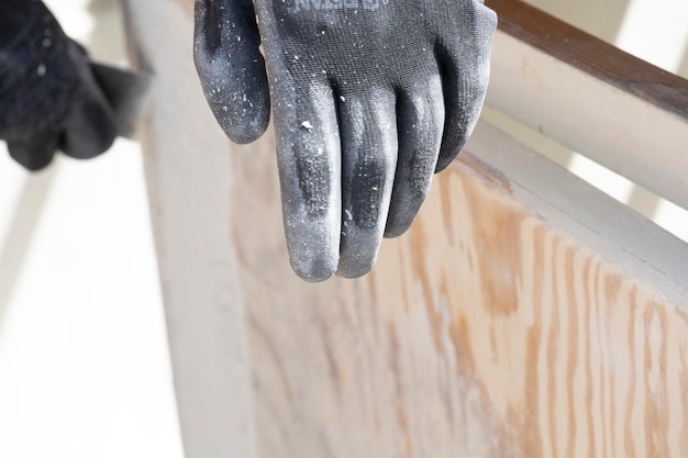 Le gant d'un ouvrier repose sur un morceau de bois.