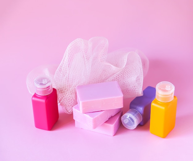 gant de toilette coloré, petites bouteilles de voyage en plastique et pains de savon