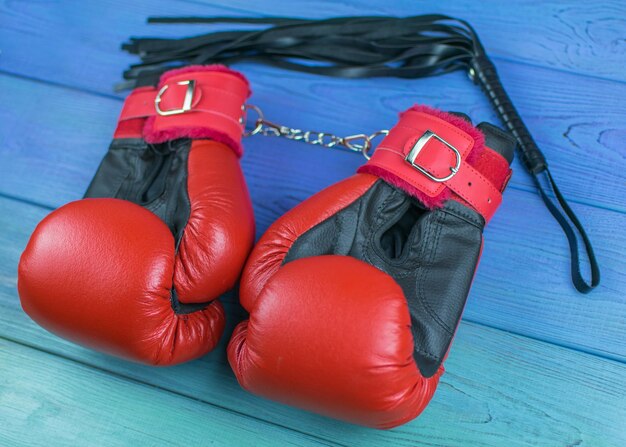 Gants de boxe attachés avec des menottes avec un fouet Concept de boxe glamour