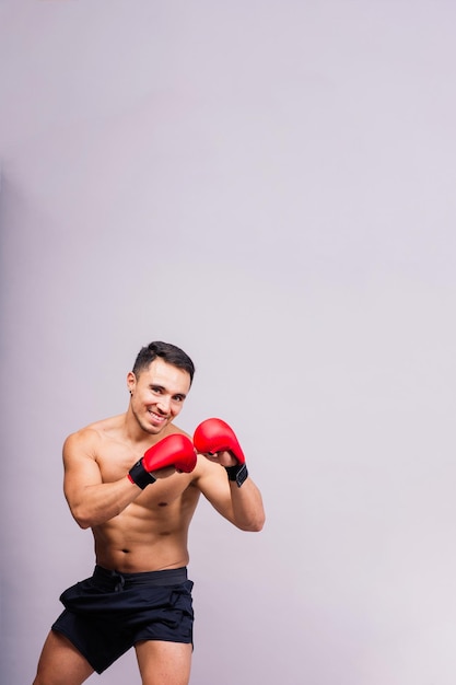 Gants de boxe homme s'entraînant au défi de combat sportif ou à la compétition mma sur fond de studio