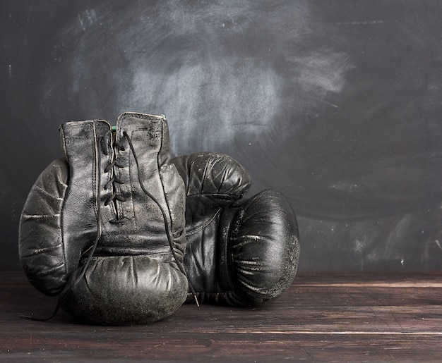 Gants de boxe vintage en cuir noir sur un espace noir