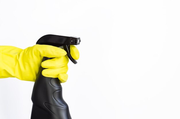 gants en caoutchouc roses tenant une bouteille de détergent en plastique noir en pulvérisation produits chimiques ménagers produits de nettoyage