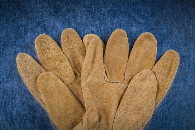 Photo gants de construction en cuir marron sur une surface métallique rayée concept de construction de version rapprochée