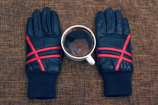 Gants en cuir à côté d'une tasse de café chaud